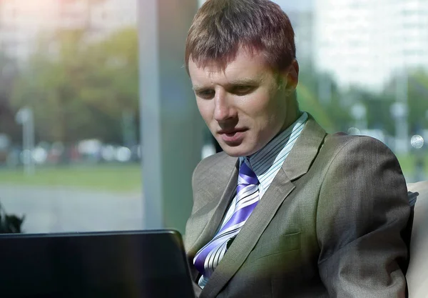 Zakenman die werken op kantoor met een laptop op zijn Bureau. — Stockfoto