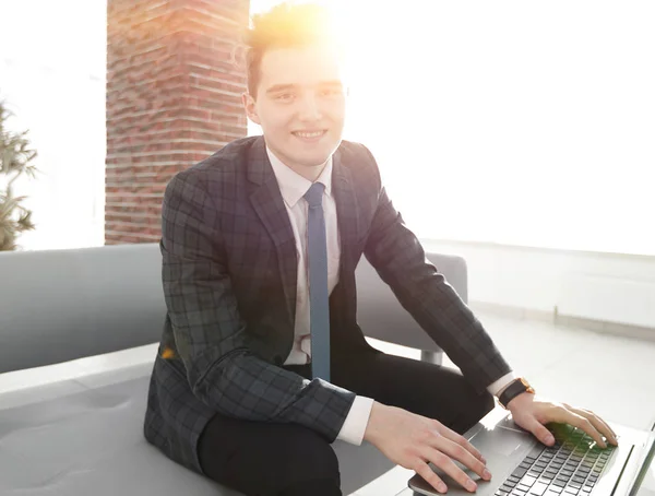 Jeune homme d'affaires travaillant avec un ordinateur portable au bureau — Photo