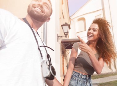 Bir çift şehrin sokaklarında yürüyor ve eğleniyor.