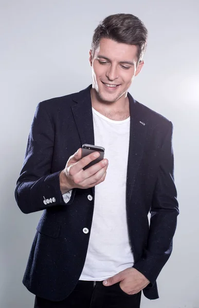 Fiatal vidám srác, mosolyogva nézett smartphone — Stock Fotó