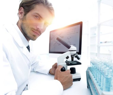 Öğrenci eğitim sınıfında mikroskop kullanarak Biyoloji