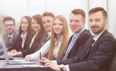 İş ekibi konferans odasındaki masada oturuyor.