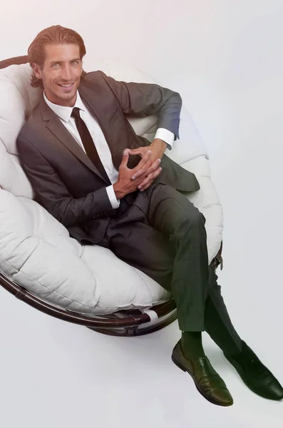 Homem sentado na grande cadeira branca — Fotografia de Stock