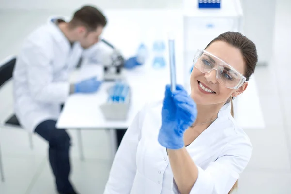 Mujer científica sonriente mirando el tubo con los resultados del análisis — Foto de Stock