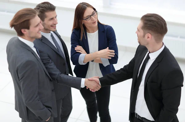 Бізнесмени тремтять руками, завершуючи зустріч — стокове фото