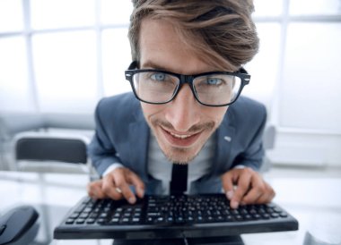 Crazy looking man typing on the keyboard clipart