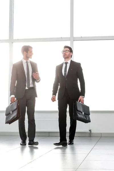 Très loin. deux hommes d'affaires marchent dans le hall du bureau — Photo