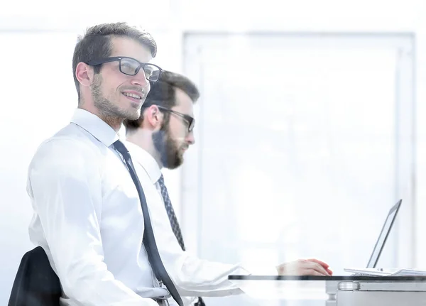 Colleghi di lavoro seduti ad una scrivania in un ufficio luminoso — Foto Stock