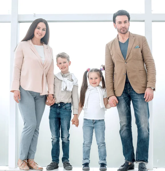 Porträt einer modernen Familie vor einem großen Fenster — Stockfoto