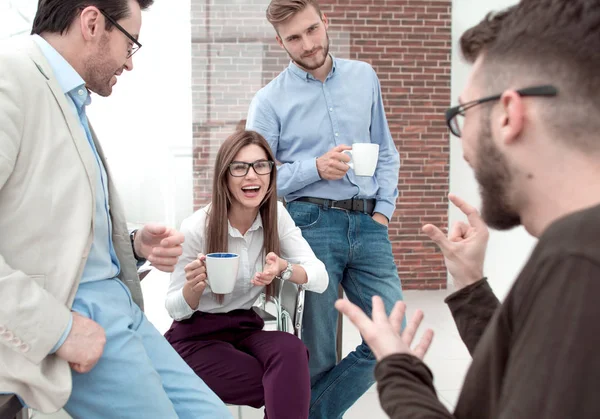 Бізнес команда розмовляє і посміхається під час кавової перерви в офісі — стокове фото