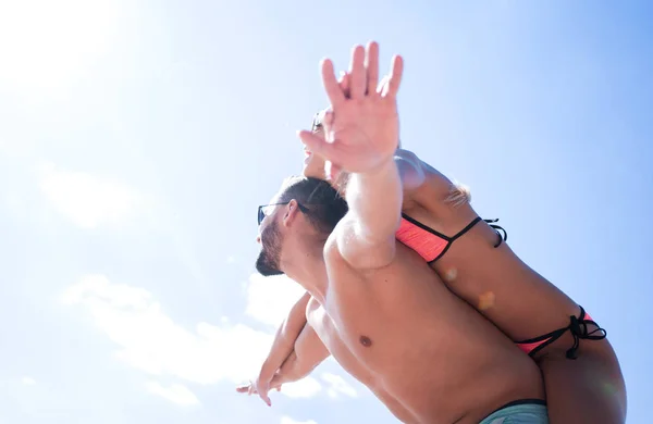 Hombre llevando mujer a cuestas en la playa. — Foto de Stock