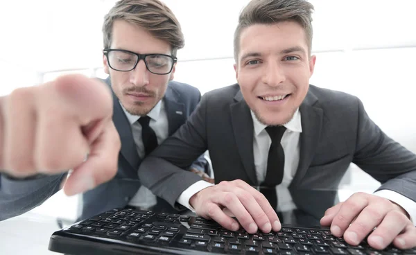 Два бізнесмена дивляться на камеру і показують пальцем — стокове фото
