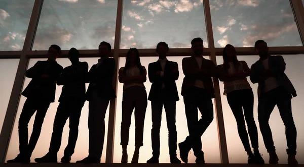 Silueta skupiny podnikatelů stojící vedle okna office — Stock fotografie