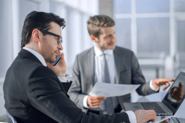 çalışanların yeni veriyi denetlemek için bir dizüstü bilgisayar kullanmak.