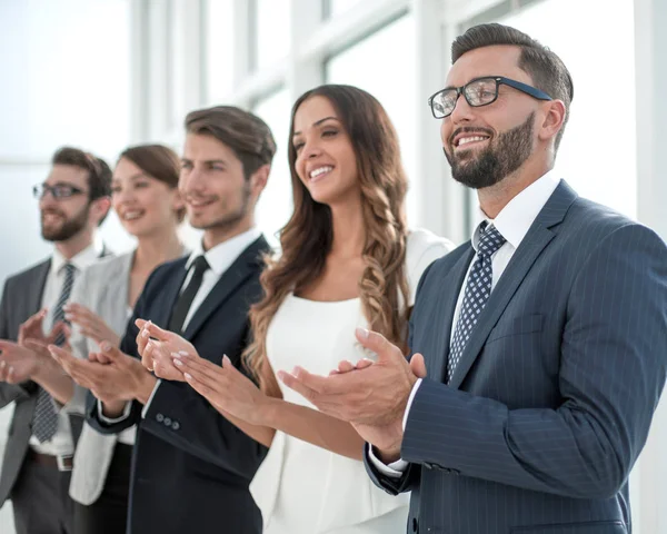 Группа бизнесменов аплодирует кому-то, стоящему в офи — стоковое фото