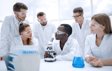 Odaklı ve ciddi kadın ve erkek kimyager laboratuvar mont ve sa