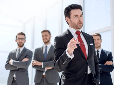 Ofiste ciddi bir iş adamı duruyor.