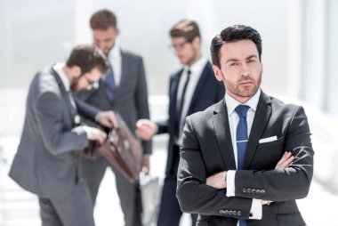 Ofiste kendine güvenen bir iş adamı duruyor.