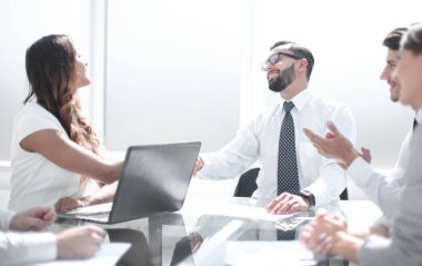 Masa başında oturarak çalışanların gülümseyen