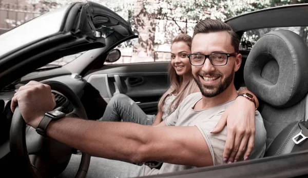 Jovem casal dentro de um carro conversível para uma viagem de um dia . — Fotografia de Stock