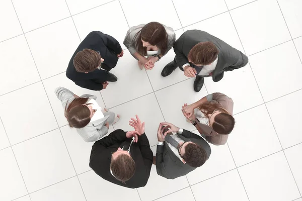 Group of employees discussing something standing in a circle — Stock Photo, Image