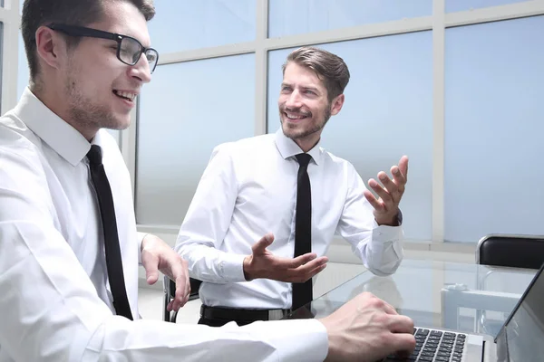 Jonge kantoormedewerker lacht, collega 's werken in de backgroun — Stockfoto