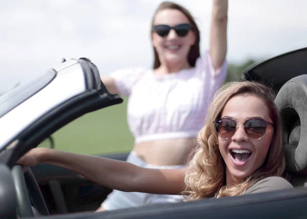 Close up. Two girlfriends traveling in a convertible car — стоковое фото