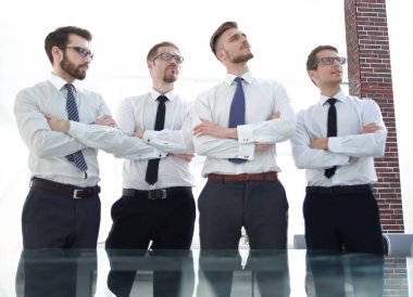 Bir grup çalışan bir ofiste dikilip fotokopi odasına bakıyorlar.