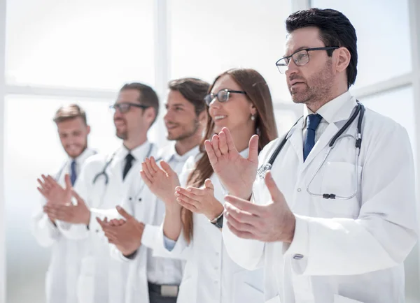 Skupina doktorů tleská, stojí v nemocnici — Stock fotografie