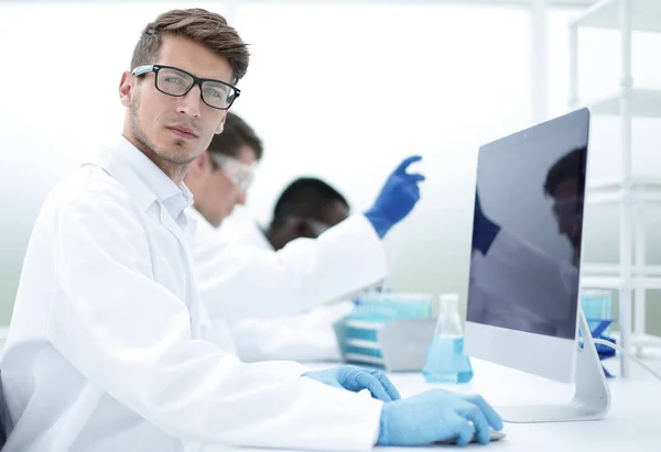 Serio joven científico sentado en el laboratorio — Foto de Stock