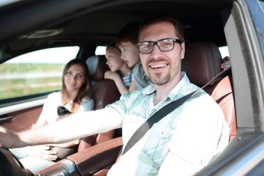 Yan görüş. Mutlu baba araba kullanıyor.