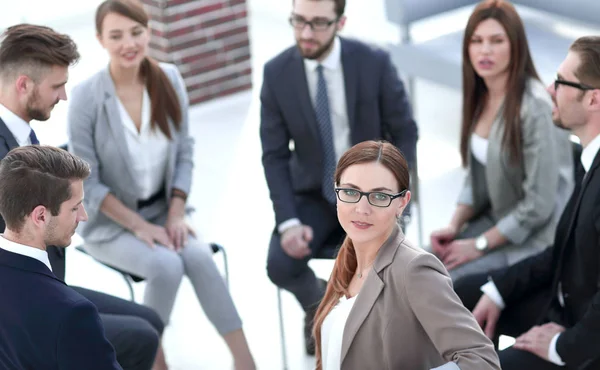 Mulher de negócios sentado em um círculo com uma equipe de negócios — Fotografia de Stock