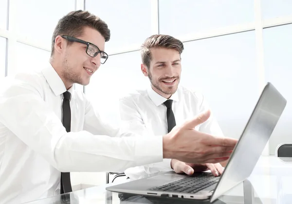 Mann zeigt seinem Kollegen Informationen auf dem Laptop — Stockfoto