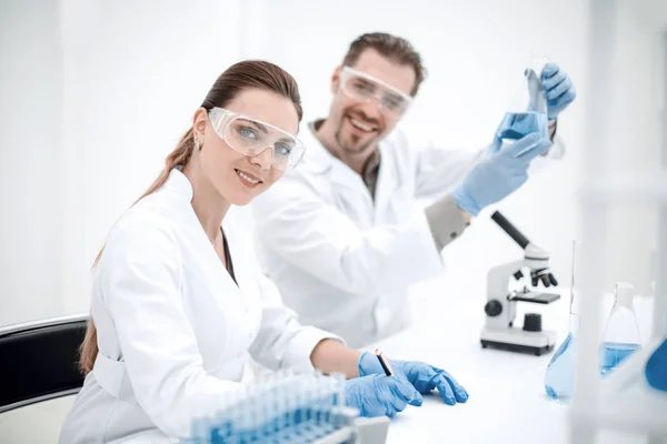 Mujer científica y su asistente trabajando en el laboratorio —  Fotos de Stock