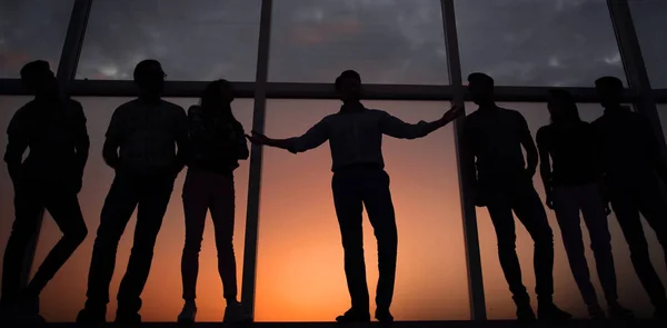 Líder y el equipo de negocios en el fondo de la ventana de la oficina — Foto de Stock