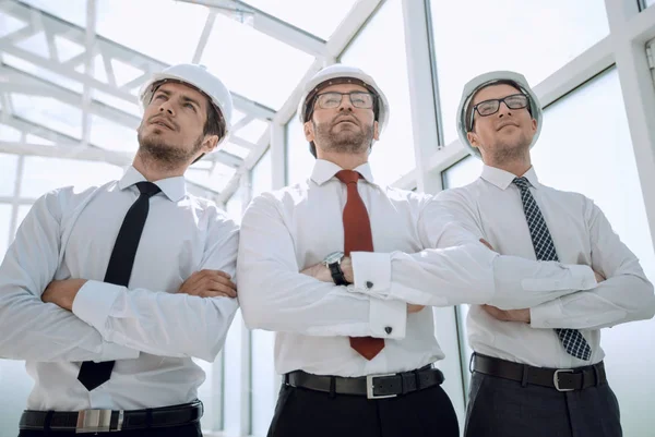 Три архітектори, що стоять у порожньому офісі — стокове фото