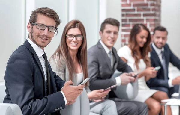 Collègues d'affaires avec leurs smartphones sur le lieu de travail — Photo