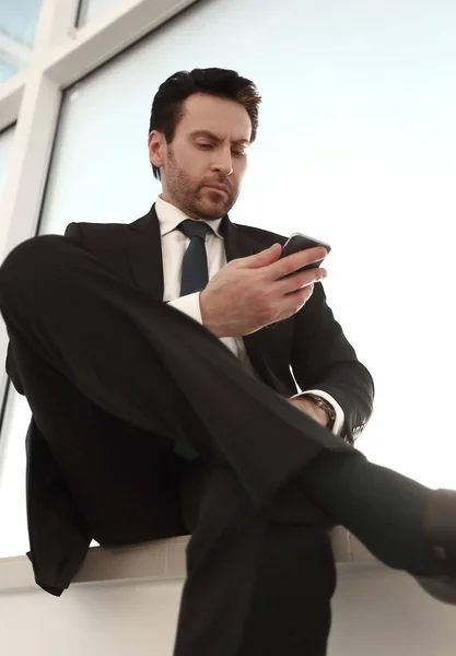 Бизнесмен набирает SMS на своем смартфоне — стоковое фото