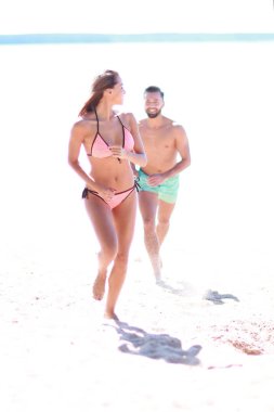 Tropik sahilde günbatımında çalışan genç Çift