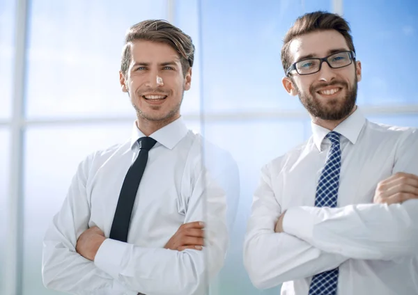 Χαμογελώντας επαγγελματικούς συνεργάτες που στέκεται σε ένα φωτεινό γραφείο — Φωτογραφία Αρχείου