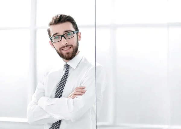 Uomo d'affari fiducioso in piedi vicino alla finestra dell'ufficio — Foto Stock