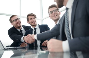 bir masa üzerinde tokalaşırken hoş geldiniz iş adamları