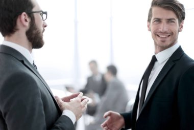 İş arkadaşları iş merkezinin lobisinde duruyorlar.