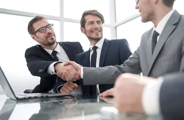 Apretón de manos socios de negocios sentados en la mesa de la oficina — Foto de Stock