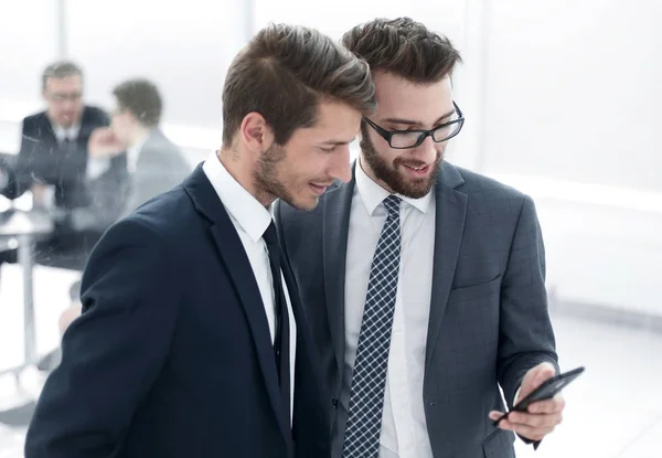Två anställda tittar på smartphone skärmen — Stockfoto