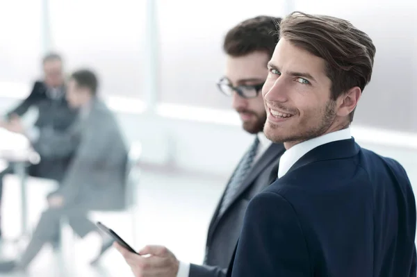 Young businessman standing in a modern office — Stock Photo, Image