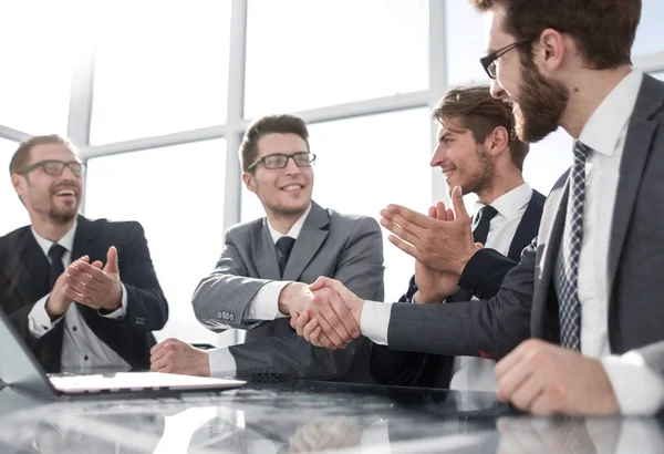 Handdruk van jonge zakelijke partners tijdens de bijeenkomst. — Stockfoto