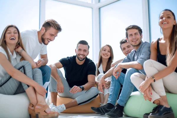 Grupo de jovens bem sucedidos sentados num novo gabinete — Fotografia de Stock