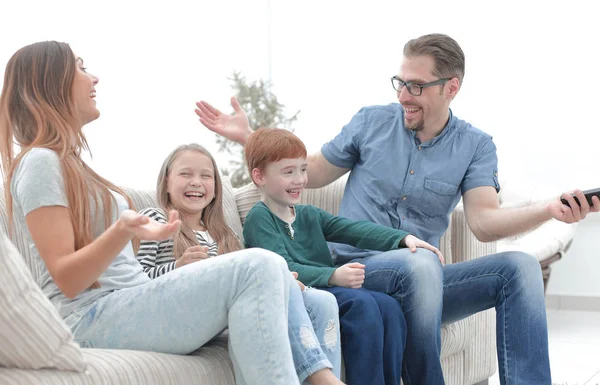 Família alegre sentado no sofá na sala de estar — Fotografia de Stock