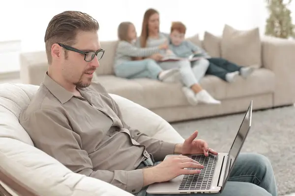 Homem de sucesso usando um laptop em sua sala de estar — Fotografia de Stock